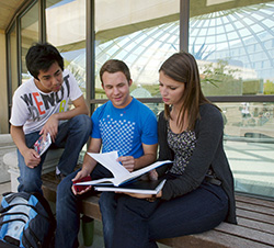 3 students conversing in front of Love Library