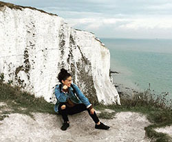 study abroad student sitting atop a cliff