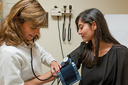 Doctor taking student's blood pressure