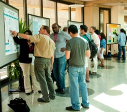 visitors review presentations at the Research Symposium