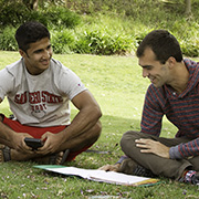 2 students sitting on the grass, reading